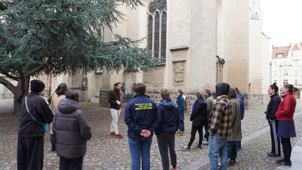 Gruppe steht vor der Stadtkirche in Wittenberg.