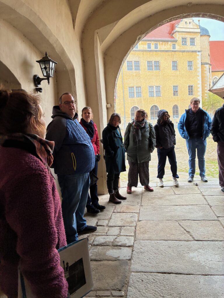 Kleingruppe steht auf dem Gedenkstättengelände des ehemaligen KZ Lichtenburg bei Prettin