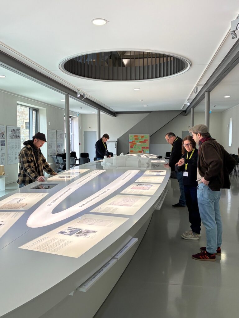 Menschen betrachten eine Ausstellungsstation.