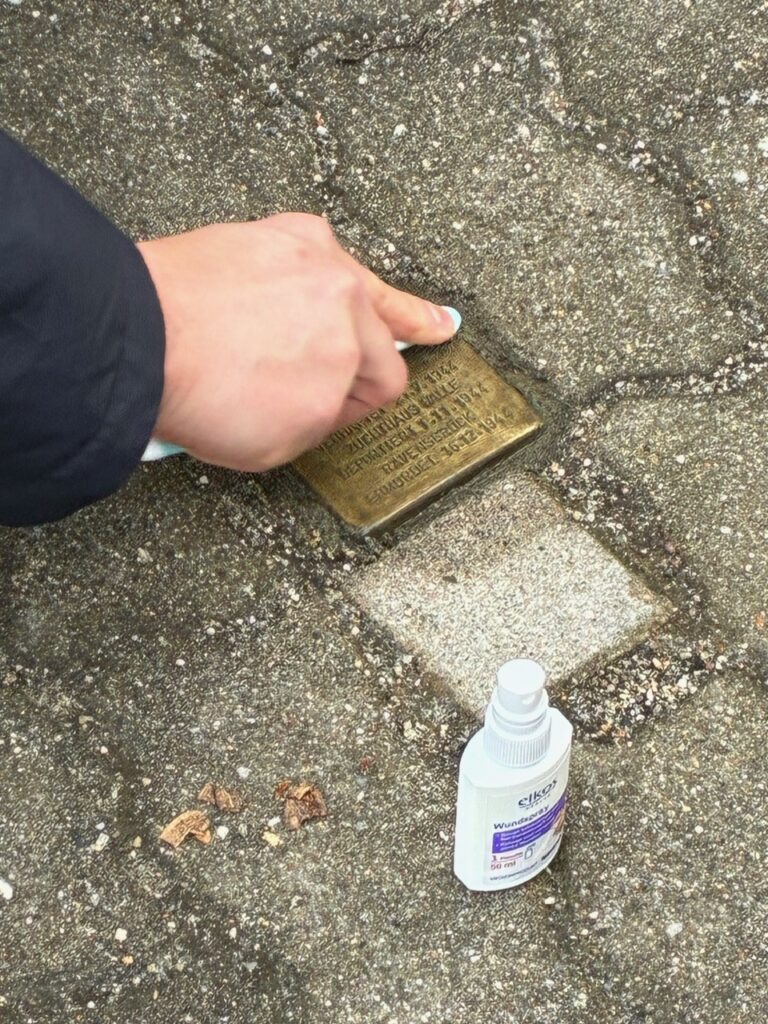 Ein Stolperstein wird geputzt
